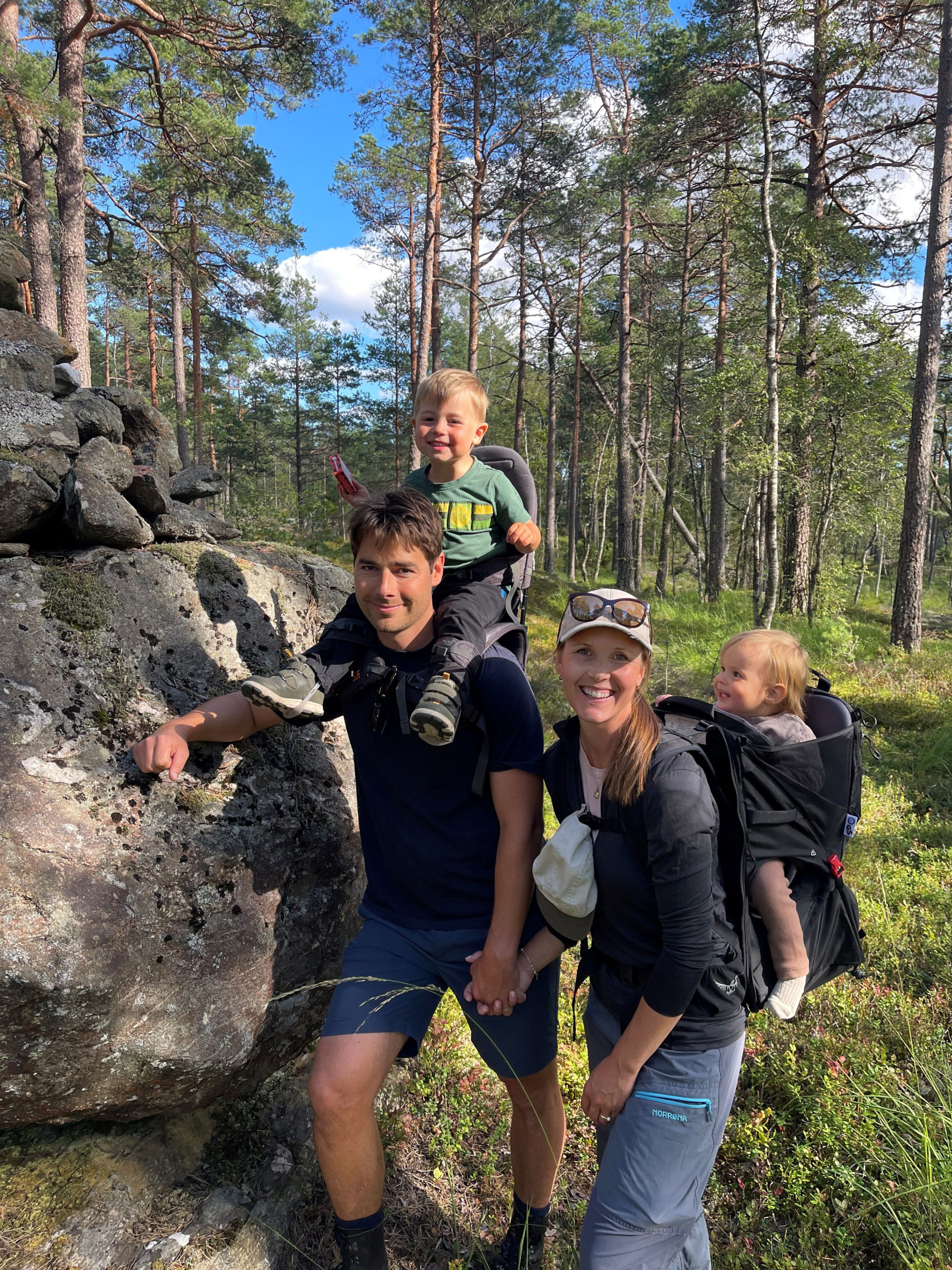 Inger-Oline Garder og mannen på tur i skogen med to barn i bæremeis.